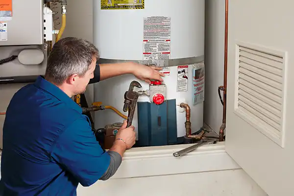 Technician performing water heater repair and replacement service in Fontana CA
